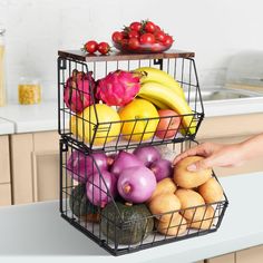 two metal baskets filled with fruit on top of a kitchen counter