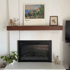 a living room with a fire place and pictures on the fireplace mantel above it