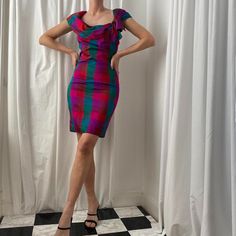 Amazing 1980s silk check/plaid Bardot mini dress by Monsoon. Bold pink/red/green check/tartan print off the shoulder knee length sleeveless wiggle dress with Bardot neckline and oversized bow detail. Such a lovely statement dress. Fitted style. Spilt to the back of the skirt. Zip fastening. Raw silk fabric with a red lining. No stretch. Size UK 12 on the label but fits more like a UK 8/10 max. Seen on a UK 8/10 (5ft9). Raw silk so has a grain/texture to the fabric. Fantastic condition. Measureme Retro Fitted Mini Length Plaid Dress, Retro Fitted Mini Plaid Dress, Retro Fitted Plaid Mini Dress, Fitted Mini Plaid Dress With Ruffles, Fitted Mini Length Plaid Dress With Ruffles, Fitted Plaid Mini Dress With Ruffles, Fitted Vintage Plaid Mini Dress, Fitted Plaid Vintage Mini Dress, Fitted Sleeveless Plaid Party Dress