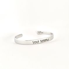 STAY STRONG This inspirational hand stamped cuff bracelet makes the perfect gift to give or treat for yourself. The cuff is 1/4 inch by 6 inches and is bent to fit most wrists. My items are hand stamped by me, making them a unique gift. Each letter is stamped individually and may not line up exactly adding to the charm and uniqueness of the gift. Visit my shop to view all of my other items by clicking here: https://www.etsy.com/shop/GemsbyJohnna Please see my shop header for current production t Personalized Inspirational Cuff Bracelet For Everyday, Everyday Inspirational Personalized Cuff Bracelet, Adjustable Personalized Cuff Bracelet For Everyday, Inspirational Stamped Adjustable Cuff Bracelet, Inspirational Adjustable Stamped Cuff Bracelet, Personalized Everyday Meaningful Cuff Bracelet, Inspirational Adjustable Cuff Bracelet For Personalized Gift, Everyday Personalized Meaningful Cuff Bracelet, Hand Stamped Bangle Cuff Bracelet