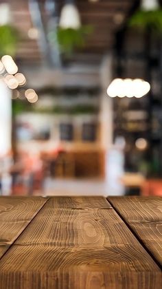 a wooden table top with blurry lights in the background