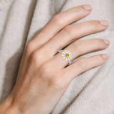 Daisy flowers represent innocence and they are usually linked to children or newborns, it is also a symbol of a new beginning. Beautifully handcrafted in sterling silver, this ring features a charming daisy and two rows of petite pave-set round brilliant-cut stones intertwine for a timeless style. The top part of the ring is rotatable, can be spun smoothly. Stunning and sparkling, this nature-inspired ring will capture your heart at first sight.Carat Weight: 0.15 ctStone Size: 3.5 mmStone Type: Jeulia® StoneNumber of Stones: 1 Stone Shape: RoundStone Color: Citrine YellowCarat Weight: 0.74 ctStone Size: 1 mmStone Type: Jeulia® StoneNumber of Stones: 74 Stone Shape: RoundStone Color: Diamond WhiteWeight: 5.6 gWidth: 3.9 mmHeight: 6.4 mmThickness: 1.5 mmMaterial: 925 SilverPlating Color: Sil Flower Shaped Promise Ring With Birthstone, White Diamond Flower Ring With Halo Setting, White Gold Promise Flower Ring, Yellow Flower Wedding Rings, Flower Birthstone Ring, Fine Jewelry Flower-shaped Birthstone Promise Ring, Flower-shaped Yellow Gold Jewelry With Halo Setting, Birth Flower Ring For Promise, Fine Jewelry Flower Halo Setting