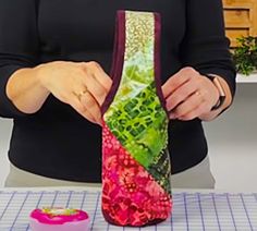 a woman is making a vase out of fabric