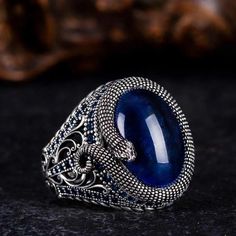 Step into the realm of mystique with our captivating Blue Tiger's Eye Ring adorned with intricate snake detailing. Crafted with care, this ring features a mesmerizing blue tiger's eye stone, exuding an aura of depth and allure. The snake motif, delicately engraved, adds an element of intrigue and symbolism to the design. Accented with shimmering zircon stones, this ring is a true statement piece that commands attention. Whether worn as a symbol of transformation or simply as a stunning accessory Snake Motif, Tigers Eye Ring, Blue Tiger Eye Stone, Grand Bazaar Istanbul, Jewelry Mens, Blue Tigers, Blue Tigers Eye, Snake Ring, Men Jewelry