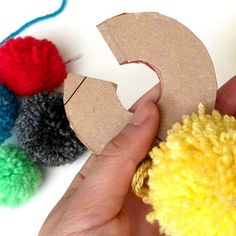 someone is making a craft with pom - poms and cardboard letters that spell out the letter c