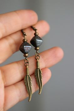 Beautiful boho earrings with black-gray bicone shape czech glass beads, tiny brass tone czech glass beads, brass feather charms and brass earring hooks. Earring hooks are from nickel free and lead free metal. The total lenght of earrings is about 76 mm including earring hooks. Other earrings of my shop you can see here: https://www.etsy.com/shop/NaTavelli?section_id=13757927 Thanks for visit! Brass Beaded Drop Earrings For Pierced Ears, Bronze Earrings With Dangling Beads For Gift, Bronze Dangling Beads Earrings For Gift, Gold Dangle Shell Earrings For Summer, Shells Earrings, Handmade Gold Shell-shaped Earrings, Handmade Shell-shaped Beachy Earrings, Ocean-inspired Dangle Shell Earrings, Beach Cowrie Shell-shaped Earrings