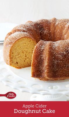 an apple cider doughnut cake on a white plate with a slice cut out