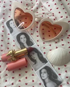 lipstick, sunglasses and shells are laying on a bed with hearts in the shape of heart - shaped frames