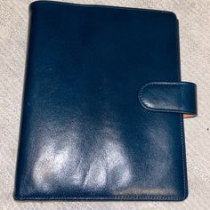 an empty blue leather notebook sitting on the floor