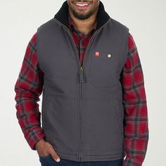 Perfect for layering over a long-sleeve flannel shirt, this da grey American Outdoorsman men's midweight vest is a versatile must-have for cooler weather. It's made from cotton-canvas with a sherpa lining for added warmth and has a collar neck, a full-zip front, side slip pockets, and a chest button pocket. Closure Type: ZipperPockets: 1 Chest Button Pocket, 2 Side Slip PocketsWarmth Factor: MidweightApparel Length: 28 InchesFiber Content: 100% CottonFabric Description: CanvasFilling Content: 10 Cheap Men's Denim Vest For Winter, Mens Ariat Vest Outfit, Men’s Western Vest Outfit, Mens Black Heated Vest Sherpa Lined, Green Fleece Vest Men, Fur Vests, Faux Fur Vest Black, Faux Fur Vest, Faux Fur Vests