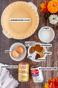 ingredients to make pumpkin pie laid out on a wooden table with autumn leaves and pumpkins