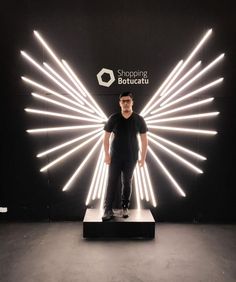 a man standing in front of a display with white lights on it's sides