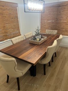 a dining room table with chairs and a basket on the centerpiece in front of it