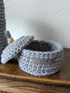 two crocheted baskets sitting on top of a wooden table