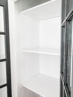 an empty white closet with open doors and shelves