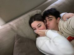 a man and woman cuddling on a couch