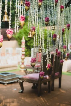 an outdoor area with pink and gold decorations hanging from it's ceiling, including chandeliers