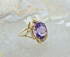 "14K Yellow Gold Attractive Modernist Bypass Amethyst and Diamond Accent Ring, medium deep amethyst oval faceted center, 14x11.5mm, 2 round diamond accents, .75\" across top, sits 3/8\" above finer, Circa 1980, Ring size 8, 5.29 grams Stock # BB185R02 Most rings are sizable for a small fee. If the ring you are considering is the incorrect size contact us for a quote. This listing contains photographs of the actual item you will receive. Our items are in excellent condition with little or no sign Oval Amethyst Ring Stamped 14k, Collectible Oval Rings With Gemstone Accents, Oval Amethyst Ring With Gemstone Accents For Formal Occasions, Oval Amethyst Jewelry Collectible, Heirloom Oval Amethyst Ring With Accent Stones, Art Deco Oval Amethyst Ring, Heirloom Style Purple Oval Amethyst Ring, Oval Amethyst Birthstone Ring In Yellow Gold, Oval Amethyst Ring With Gemstone Accents