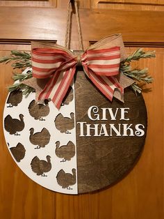 a door hanger that says give thanks and two turkeys with red bows on it