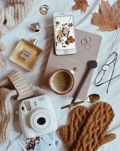 the contents of a woman's purse laid out on a bed next to her accessories