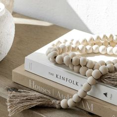 a stack of books with wooden beads and tassels