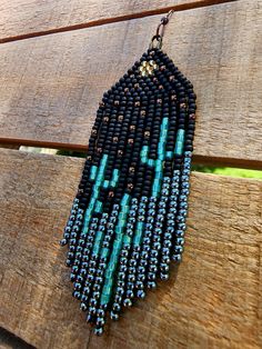 a black and blue beaded necklace hanging on a wooden surface