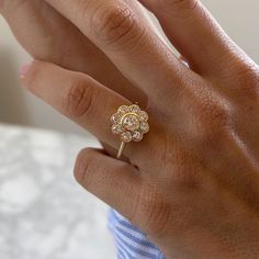 a woman's hand with a diamond ring on top of her finger and the other hand holding an engagement ring