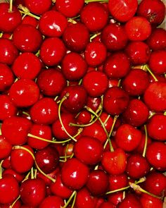 a box filled with lots of red cherries