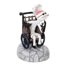 a figurine sitting on top of a wheel chair