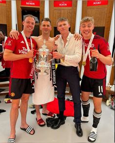 three men are posing with their trophies in the dressing room