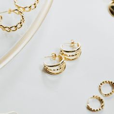 Stunning and elegant, our Abigail Earrings in Gold are the perfect addition to any outfit. These triple-loop hoop earrings are crafted from high-quality 18k gold overlay, adding a touch of luxury to your style. Elevate your look with these timeless and versatile earrings. *Also available in SILVER PRODUCT DETAILS Diameter: 3/4" Width: 3/8" Closure: Post Metal: 18k Gold Plated Brass Plated Hoop Drop Earrings For Anniversary, Trendy Yellow Gold-plated Cartilage Earrings, Modern Plated Hoop Earrings For Gift, Chic 14k Gold Filled Hoop Earrings, Everyday Gold-tone Plated Earrings, Trendy Gold Plated Hoop Earrings, Trendy Yellow Gold Hoop Earrings For Anniversary, Trendy Gold Plated Anniversary Earrings, Gold Hoop Earrings For Everyday Elegance