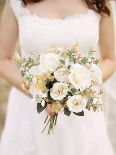 a bride holding a bouquet of white flowers