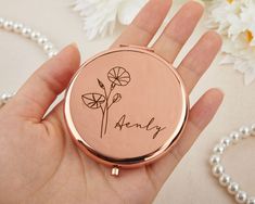 a person holding a small compact case with flowers on it and the word honey written in cursive writing