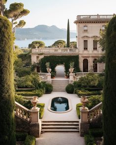 an outdoor garden with steps leading up to a pool in front of a large house