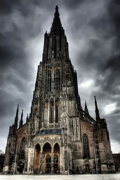 an old cathedral with dark clouds in the background