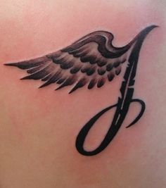 a tattoo with an angel wing and scissors on the back of someone's shoulder