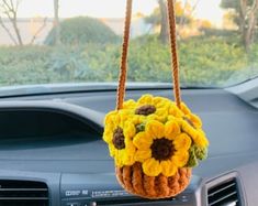 a sunflower purse hanging from the dashboard of a car