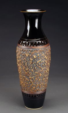 a black and brown vase sitting on top of a table