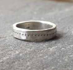 A great chunky ring with a free hand stamped ring of dots going all the way around. The silver has a hammered rough luxe texture from being beaten into shape. Comfortable to wear and strong enough for everyday. Perfect as an alternative silver wedding band if desired. Due to the making process each ring is unique so please allow for some variation as your ring will be made to order. Please send your ring size when ordering. The video shows the ring with a flush set pink sapphire, please message Thick Silver Ring, Chunky Silver Jewellery, Silver Hammered Ring, Texture Jewelry, Small Silver Hoop Earrings, Minimalist Silver Ring, Rough Luxe, Chunky Silver Rings, Hand Stamped Ring