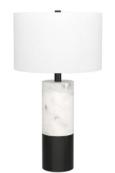 a black and white table lamp with a white shade on the top, sitting against a white background