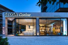 the entrance to stosa cuisine in an urban setting at dusk with its lights on