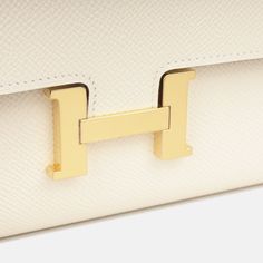 The Hermes Constance To Go Wallet is the perfect accessory as it is sleek, stylish and sophisticated. This wallet can easily hold all your cards, bills, change and receipts with a removable shoulder strap that transforms this iconic style into a multi-functional piece. Remaining a true investment piece that will never lose its value, not only beautiful and chic, but it is one that you will never fall out of love with. SPL Exterior  Nata Epsom Leather  Gold tone hardware  Hermès logo stamp ‘H’ tab closure Removable and non-adjustable leather thin shoulder strap Slip pocket at rear Date Code U - 2022 Production Brand New Condition   Interior  Smooth leather interior   Two open compartments Large middle zip pocket Four card slots Two slip pockets Brand New Condition  Sold with box, felt, shou