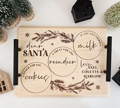 a wooden cutting board with some words written on it next to small houses and trees