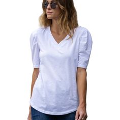 Introducing the Amaryllis Women's V-Neck Puff Sleeve Tee, where casual meets elegance. This tee features a flattering V-neckline that enhances the neckline, while the puff sleeves with gathered shoulder detail add a stylish and feminine touch. Made from soft stretch fabric, this tee provides comfort and ease of movement, making it an ideal choice for everyday wear. The relaxed fit ensures it pairs effortlessly with jeans or skirts for a versatile look. Whether you're running errands or meeting f Stretch V-neck T-shirt For Day Out, Casual V-neck Cotton Puff Sleeve Top, Casual Short Sleeve V-neck Top For Brunch, Relaxed Fit V-neck Tops For Brunch, Casual V-neck Top With Short Sleeves For Brunch, White V-neck Puff Sleeve Top For Brunch, Feminine Fitted V-neck Blouse, Cotton V-neck Puff Sleeve Top For Brunch, Feminine V-neck Tops With Relaxed Fit