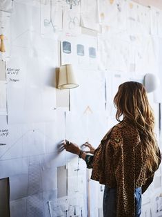 a woman standing in front of a white board with writing on it