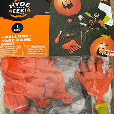 an assortment of halloween decorations on display in a package with plastic gloves and pumpkins