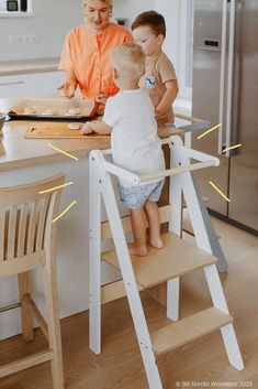 a woman and two children are in the kitchen