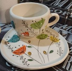 a coffee cup and saucer decorated with flowers