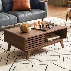 a living room with a couch, coffee table and chess board on the rug in front of it