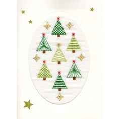 a cross stitch christmas card with green and red trees in the center, surrounded by stars